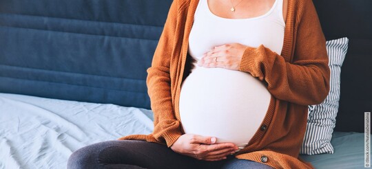 Schwangere Frau mit Blasenentzündung fasst sich an den Bauch